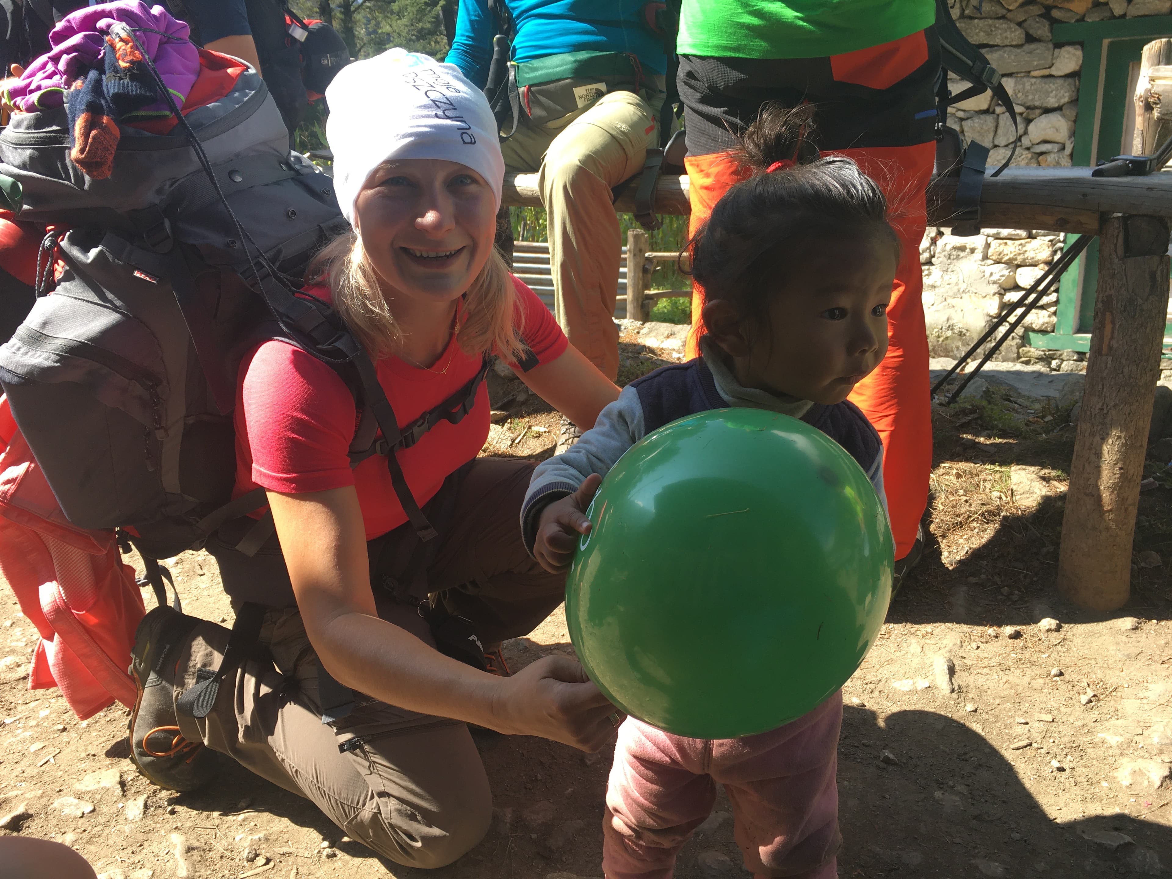 Aleksandra Kost z nepalskim dzieckiem bawiącym się zielonym balonikiem