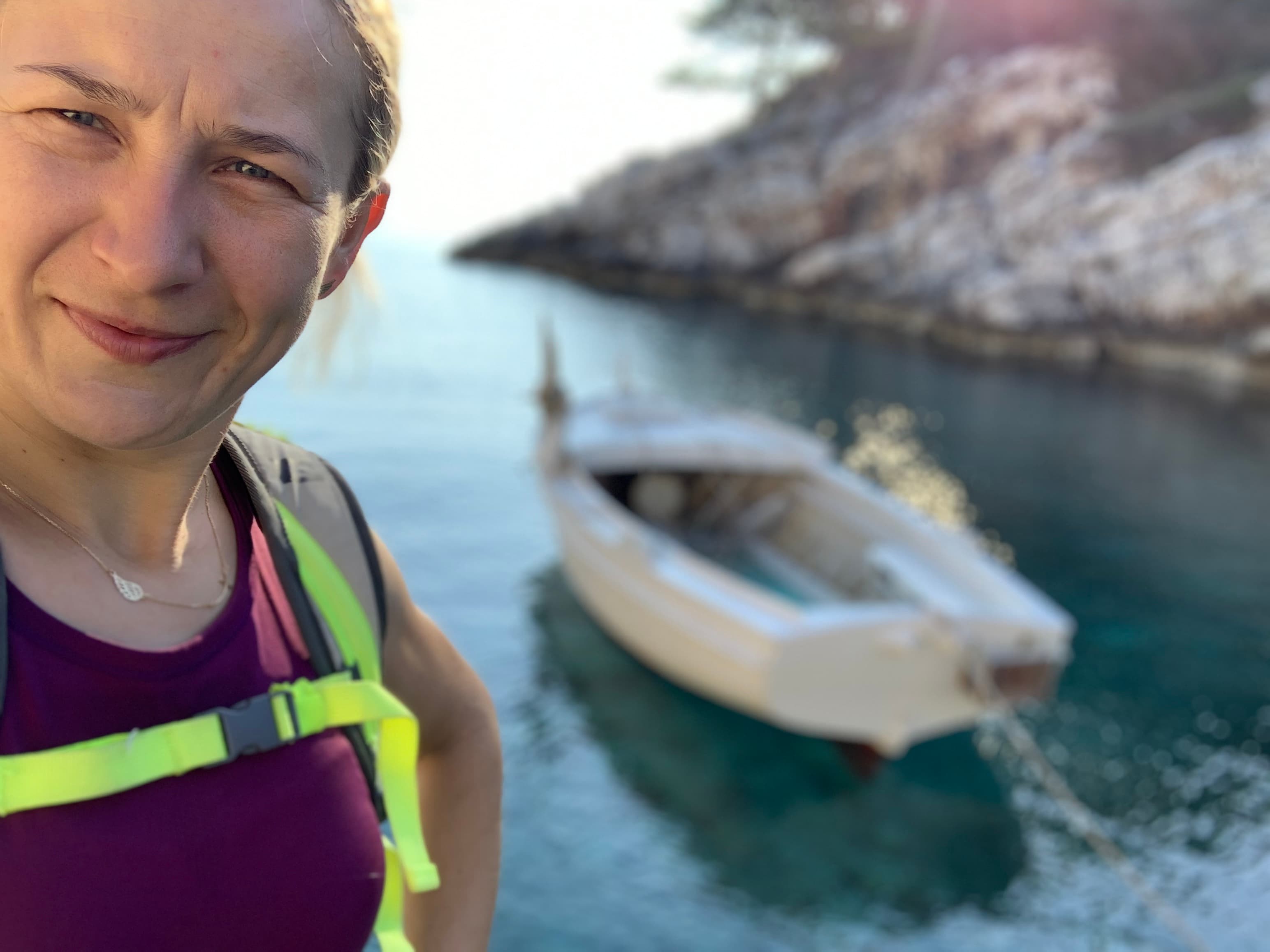 Aleksandra Kost przy turkusowej zatoce Lastova z białą łódką w tle